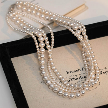 The star wears the same style in multiple layers, one  pearl necklace, and wears more strong lights to send to ladies