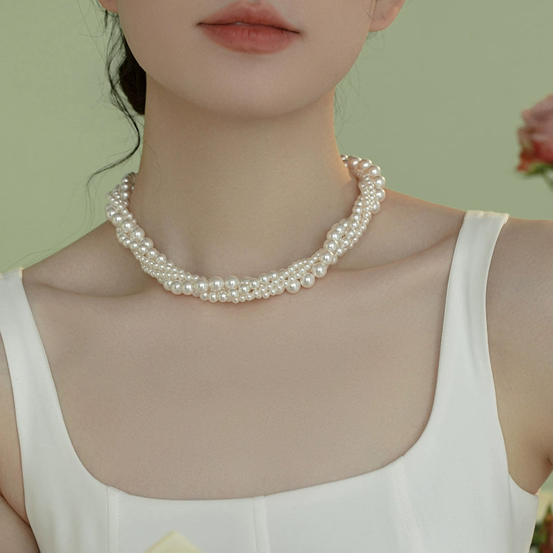The star wears the same style in multiple layers, one  pearl necklace, and wears more strong lights to send to ladies