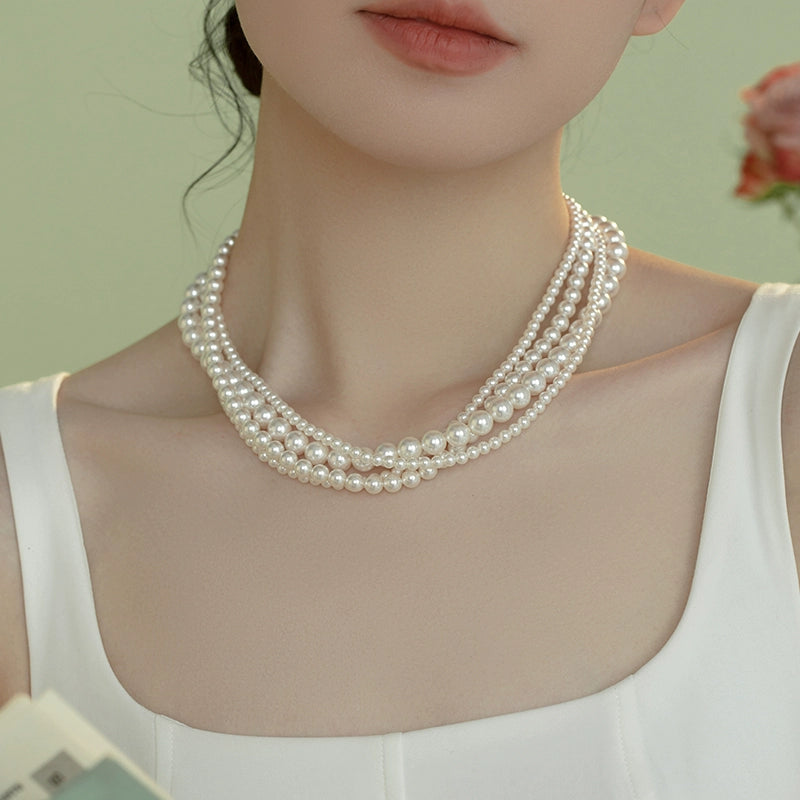 The star wears the same style in multiple layers, one  pearl necklace, and wears more strong lights to send to ladies